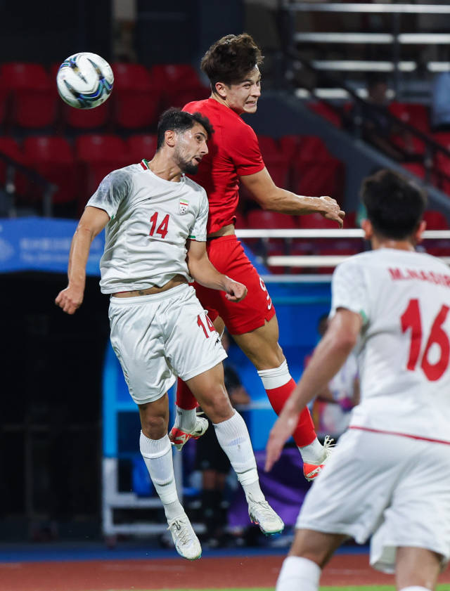 10月1日，中国香港队球员安永佳（上）与伊朗队阿米尔·贾法里·赛加拉尼（左）争顶头球。新华社发